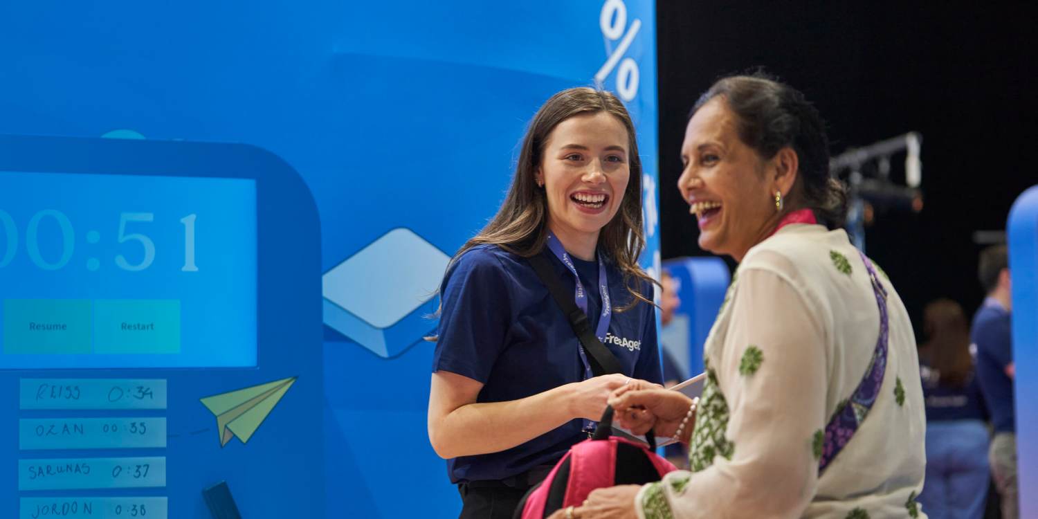 Two women smiling and laughing at an Freeagent event booth