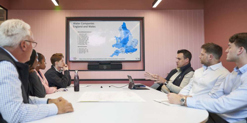 Photo of 7 Utility Results employees watching a presentation.