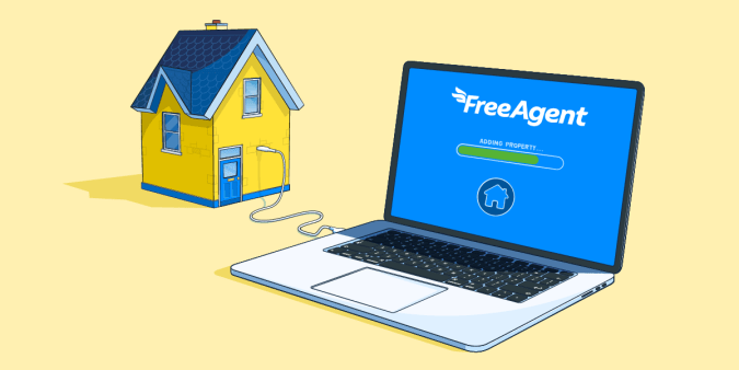 A laptop beside a small house